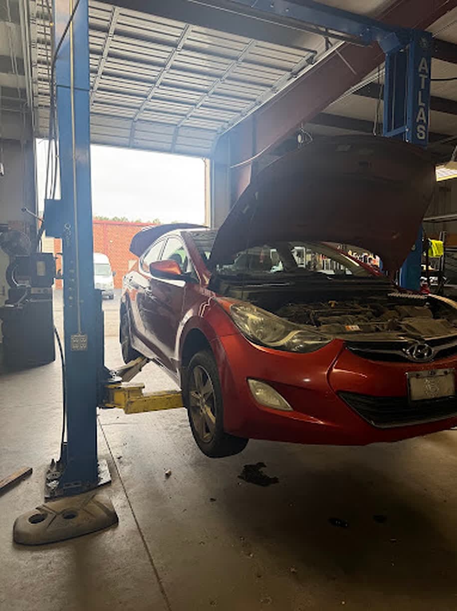 A customer's sedan up on the lift for service at Unlimited Tire & Service in Buford, GA